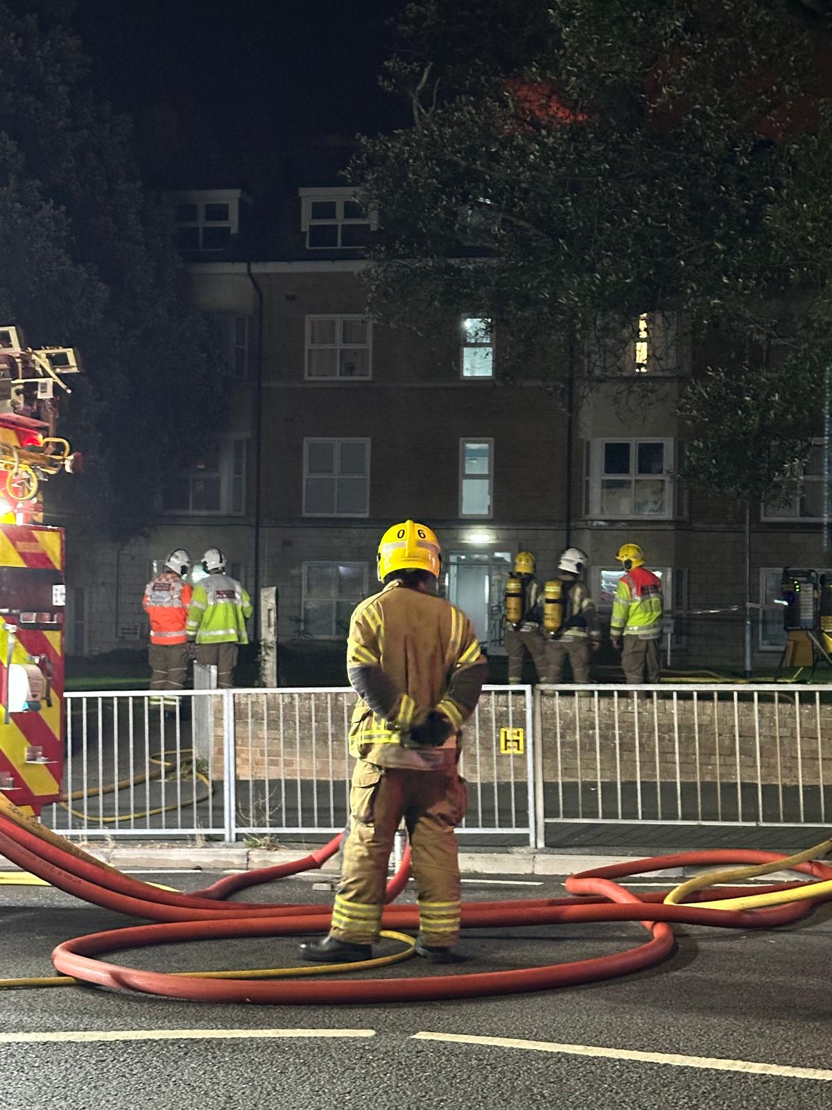Firefighters entering the burning property